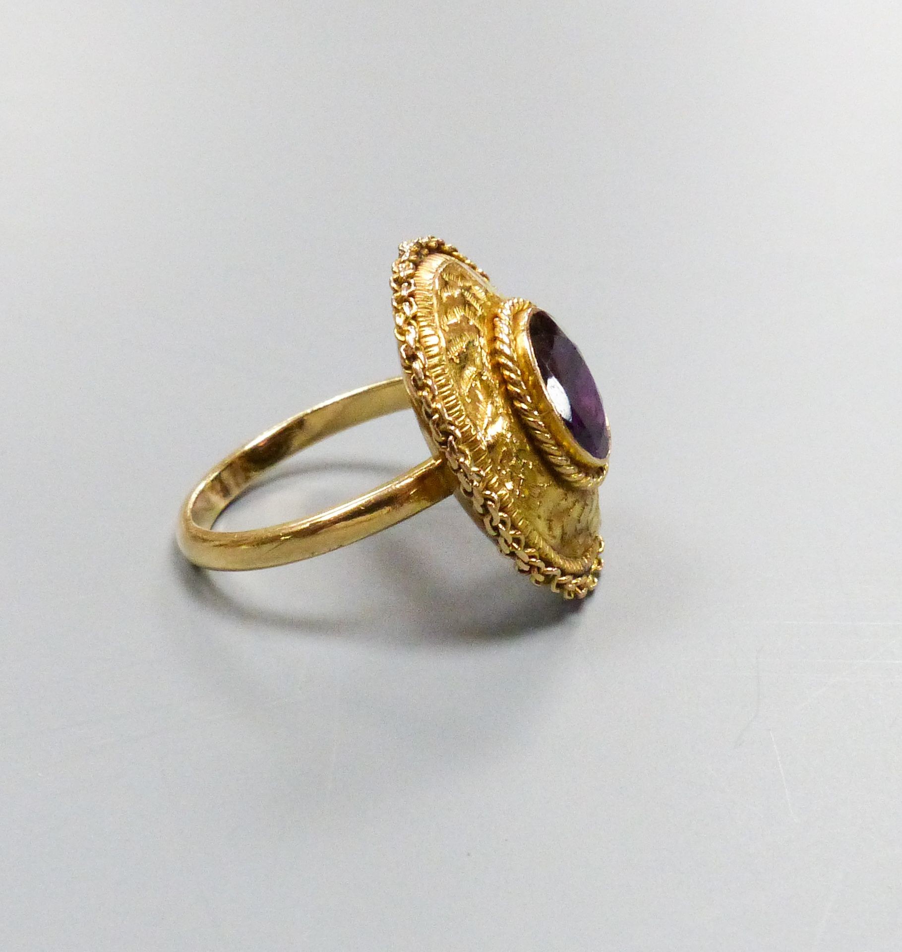 A 19th century engraved yellow metal and garnet set oval dress ring, with rope twist border (ring head loose), size N, gross weight 4.4 grams.